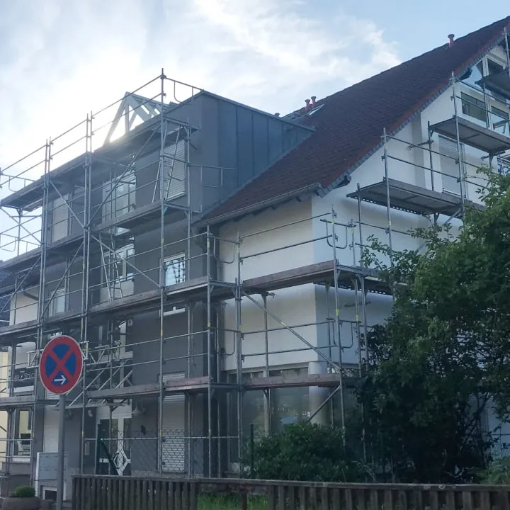 Mehrgeschossiges Wohnhaus an einer Straße, Fassade bis zum Dach eingerüstet